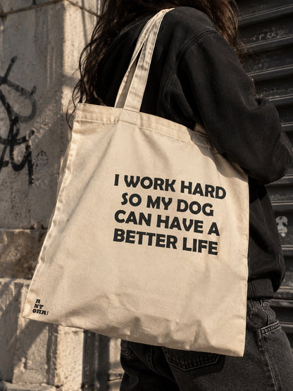 Μπεζ tote bag με στάμπα I WORK HARD SO MY DOG CAN HAVE A BETTER LIFE φορεμένη στον ώμο