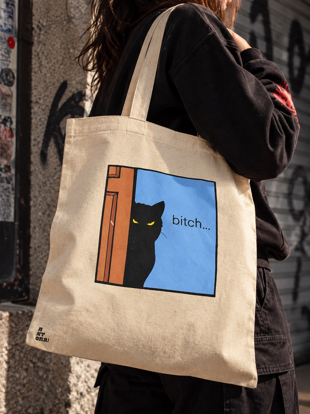 Μπεζ tote bag με μαύρη γάτα και μήνυμα bitch φορεμένη στον ώμο