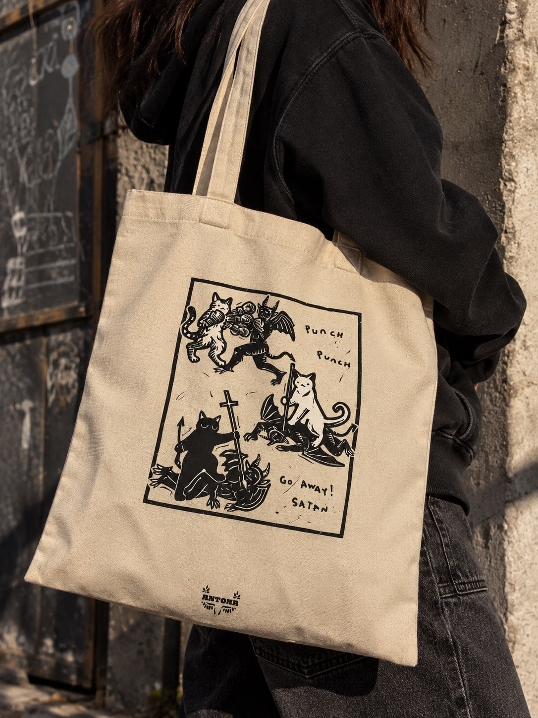 Μπεζ tote bag με σχέδιο γάτων και δαιμόνων φορεμένη στον ώμο