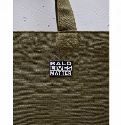 Bald Lives Matter pin πάνω σε πράσινη tote bag