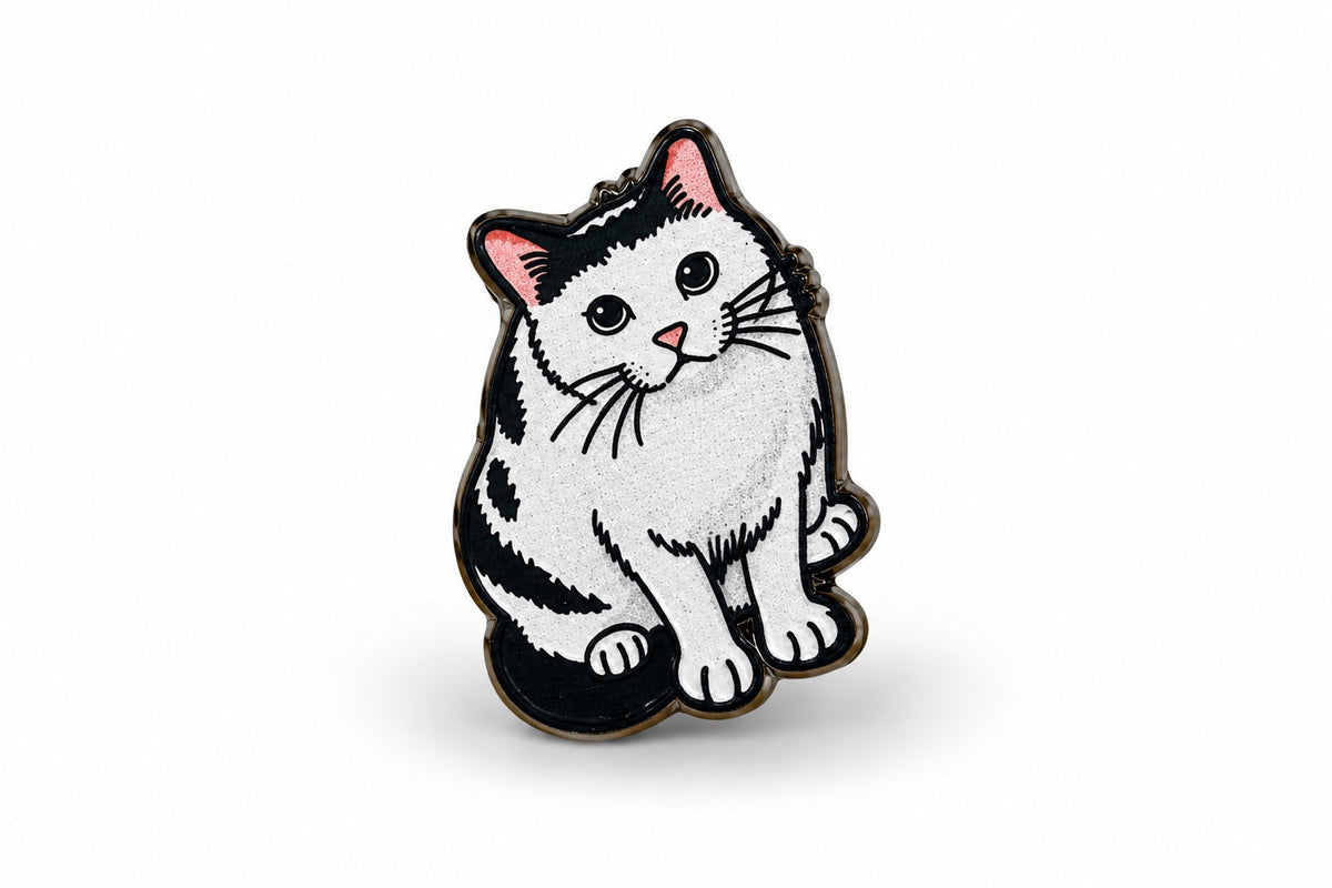 Close-up product photo of a black and white cat wooden printed pin