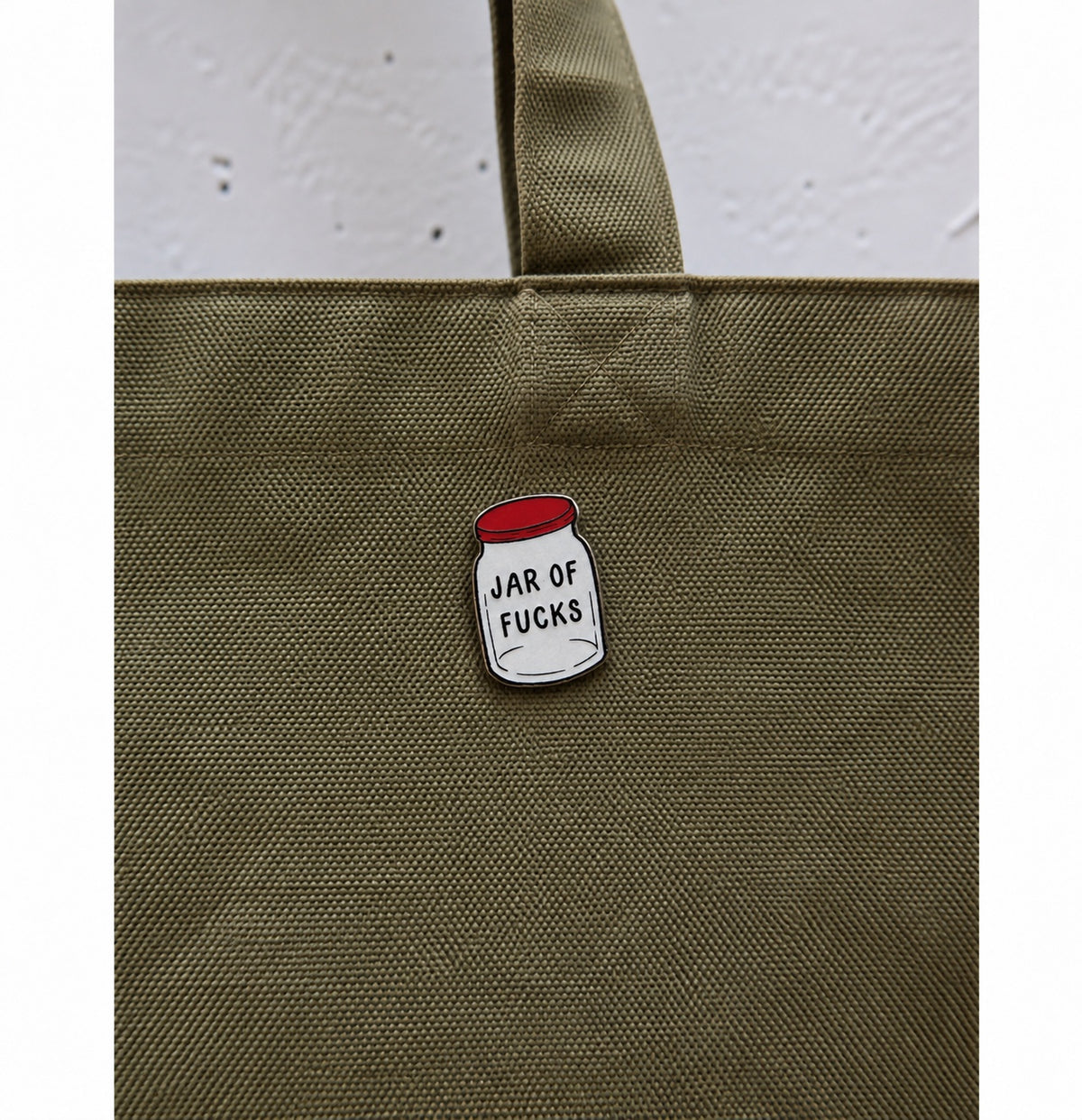 Jar of Fucks ξύλινο pin πάνω σε πράσινη tote bag