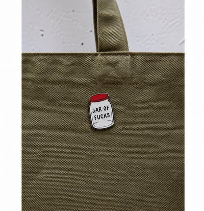 Jar of Fucks ξύλινο pin πάνω σε πράσινη tote bag