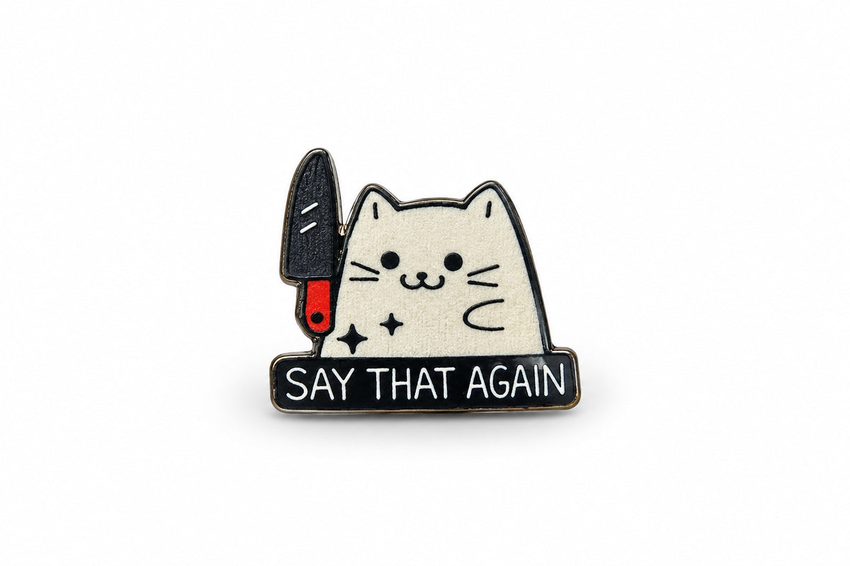 Close-up product photo of white cat with knife Say That Again pin